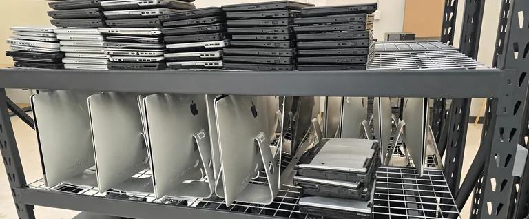 Laptops and desktop computers organized on equipment shelves